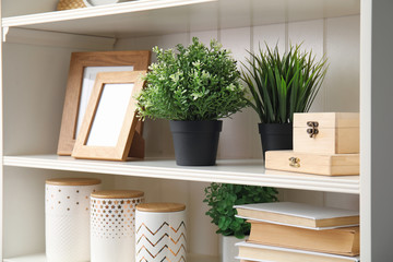 White shelving unit with plants and different decorative stuff