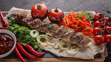 Fototapeta na wymiar Food banner. Chicken shush kebab. Zucchini, green peppers, tomatoes, grilled potatoes and mushrooms, various herbs, tomato sauce and spices