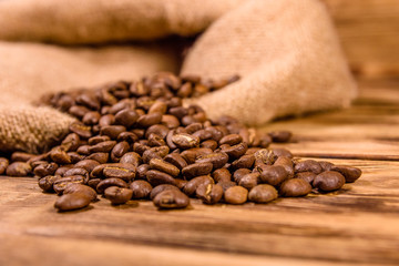 Sackcloth and scattered coffee beans on wooden table