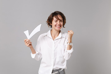 Happy young business woman in white shirt posing isolated on grey wall background in studio....
