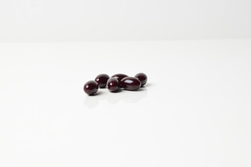 Group of astaxanthin capsules scattered on a white background.