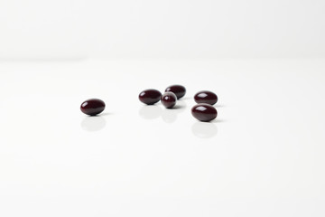 Astaxanthin capsules scattered on a white background.