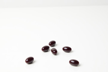 Astaxanthin capsules scattered on a white background.