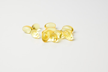 Fish oil capsules on a white background. Copy space. Side view.