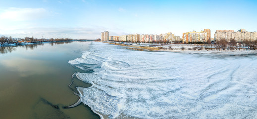 winter panorama landscape - wide snowy beach of the shallowed Kuban River near the city of Krasnodar in the early sunny morning