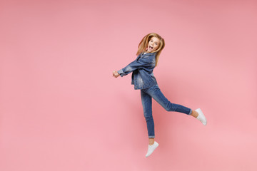 Fototapeta na wymiar Pretty little blonde kid girl 12-13 years old in denim jacket isolated on pastel pink wall background children studio portrait. Childhood lifestyle concept. Mock up copy space. Jumping, having fun.