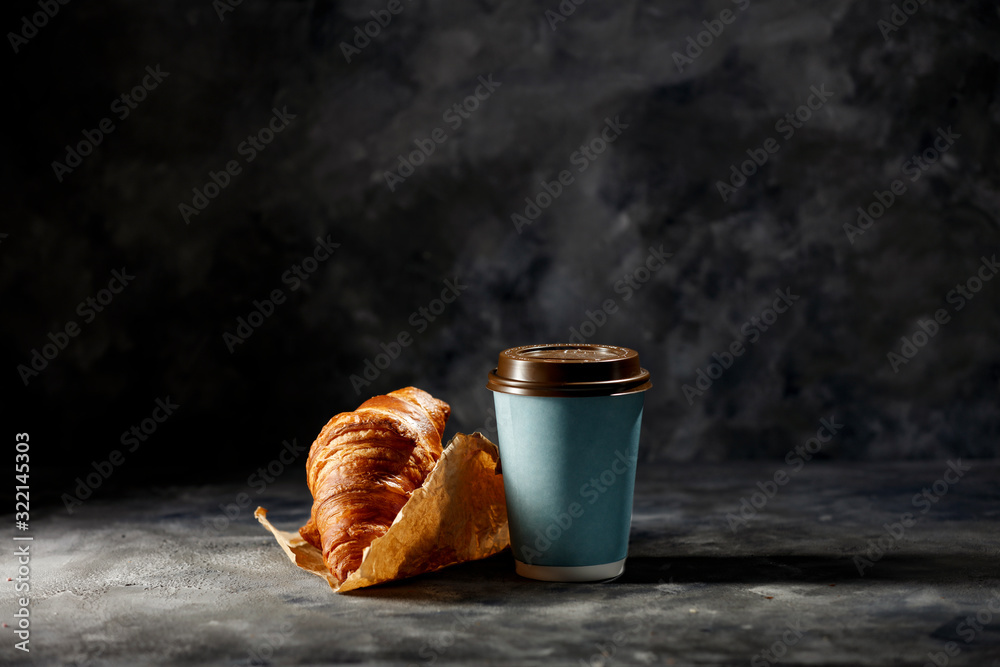 Wall mural fresh hot coffee in paper cup and sweet cake on dark mood background.