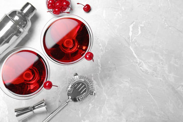 Glasses of fresh cocktail with cherries on marble table, flat lay. Space for text