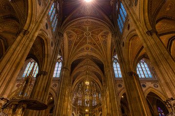 Fototapeta premium golden interior of catholic cathedral church indoor environment walls dome and illumination lamp religion building glory atmosphere
