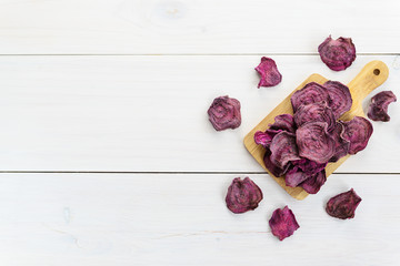 Beetroot chips on a wooden board. Horizontal orientation, copy space, top view.