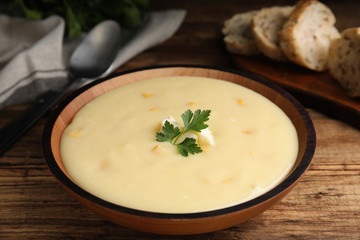 Delicious corn cream soup served on wooden table