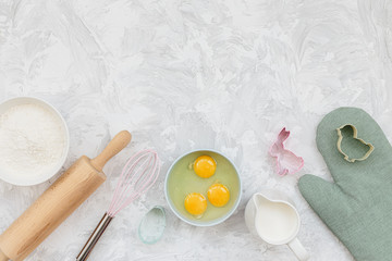 Flour eggs milk and kitchen utensils on light white gray texture background