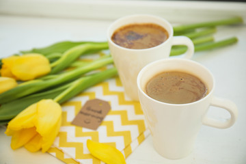 Aromatic coffee, beautiful flowers and words GOOD MORNING wish on light table