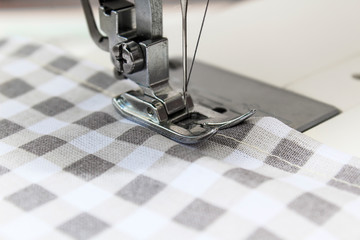 Sewing machine with fabric and thread on a whine background. Close up and copy space.