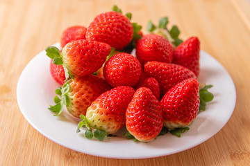 strawberries in a bowl on wooden table