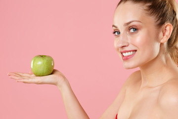 Obraz na płótnie Canvas Close up blonde half naked woman 20s perfect skin nude make up hold apple isolated on pastel pink wall background studio portrait. Skin care healthcare cosmetic procedures concept. Mock up copy space.