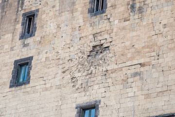Fototapeta na wymiar Facade of the Angevin male in Naples hit by a cannonball