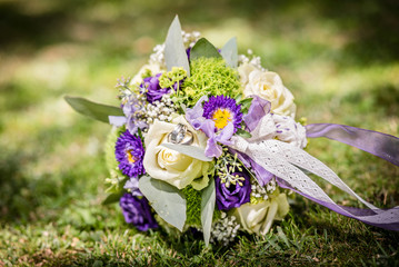 Bridal bouquet with rings in grass