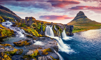 Dramatic morning view of popular tourast destination - Kirkjufellsfoss Waterfall. Colorful sunrise on Snaefellsnes peninsula, Iceland, Europe. Beauty of nature concept background..