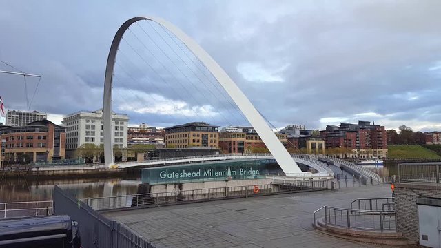 Cyclist and pedestrians crossing the Gateshead Millennium Bridge, spanning the River Tyne, Newcastle upon Tyne, England, UK
