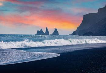 Exoti summer sunrise on Reynisdrangar cliffs in Atlantic ocean. Exciting morning scene of black sand beach in Iceland, Vik location, Europe. Beauty of nature concept background.