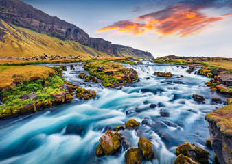 Romantic summer view of small waterfall near Bjodvegur road. Impressive sunrise on Iceland, Vik...