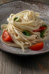 coocked egg noodles with tomatoes and basil