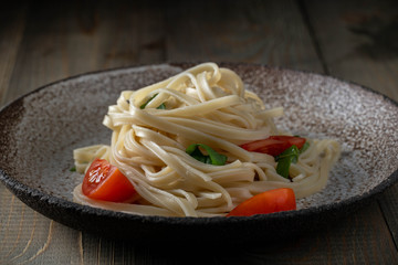 coocked egg noodles with tomatoes and basil