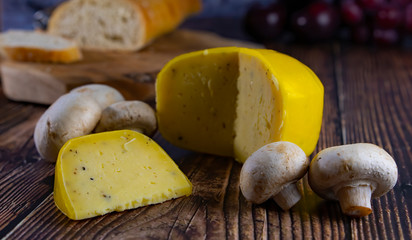 Yellow Netherlands cheese ,traditional soft, old, Pepper, mushrooms served with bread