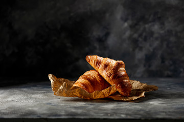 Fresh tasty croissants on dark background and free space for your decoration. 