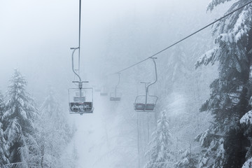 Empty ski chair lift in the forest. Extreme snow conditions, Korbielow village, Poland