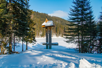 Commemorative pillars of the snowy alpine lake Synevyr