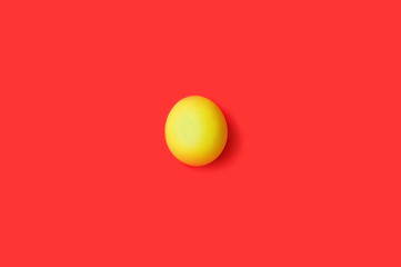 easter yellow egg on red background. Easter background. Top view