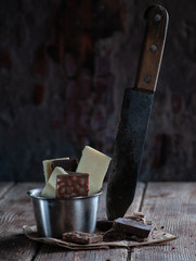 white and black chocolate on a wooden table with orange and knife