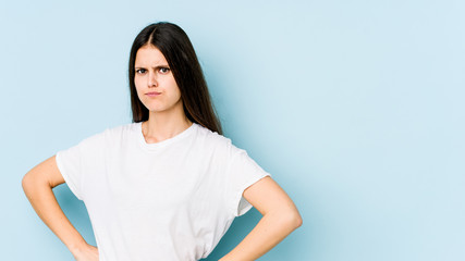 Young caucasian woman isolated on blue background confused, feels doubtful and unsure.