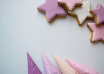 pink, white, purple stars next to pastry bags filled with icing
