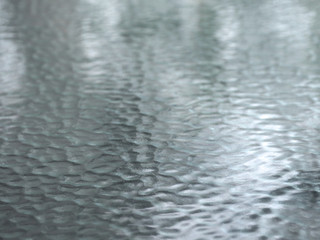 The texture of embossed glass. Glare on the glass surface. Fascinating glass background.