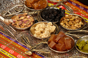 Traditional oriental sweets - Turkish delight, pastille, nuts, raisins, dried fruits, candied fruits, nut paste, pistachios.Beautiful serve on a metal tray