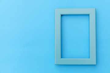 Simply design with empty blue frame isolated on blue pastel colorful background. Top view, flat lay, copy space, mock up. Minimal concept.