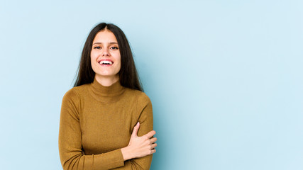Obraz premium Young caucasian woman isolated on blue background laughing and having fun.