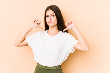 Young caucasian woman isolated on beige background feels proud and self confident, example to follow.