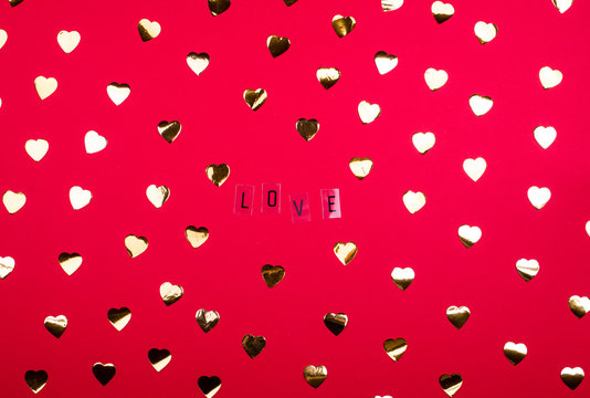 Bright red background, with golden blettes and hearts and the word love.