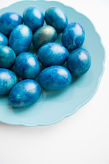 blue eggs laid on a blue plate on the table for Easter