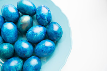 blue eggs laid on a blue plate on the table for Easter