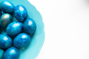 blue eggs laid on a blue plate on the table for Easter