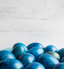blue eggs with a tint on a white background for Easter