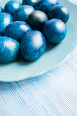 blue eggs laid on a blue plate on the table for Easter