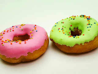 two colorful donuts isolated on a white background.