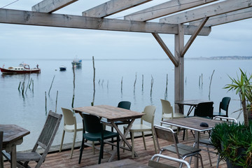 terrace oyster restaurant seaside chairs and wood table on beach village of l'herbe in Cap Ferret France