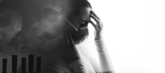 Double exposure of female face and factory chimneys polluting air. Portrait of young woman in protective respirator suffering from severe headache. Girl wearing medical mask. Free space for text.